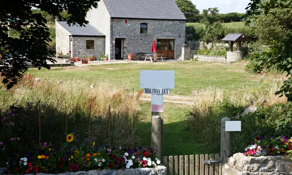 A holiday cottage with a sign at the gate saying "Holiday Let".